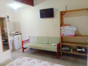 Cette chambre dispose d'un canapé et d'une télévision murale. dans l'établissement Chalé em Penedo - Linda Vista Condomínio, à Itatiaia