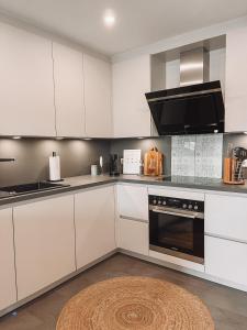 een keuken met witte kasten en een zwarte oven bij Ella House in Lingen