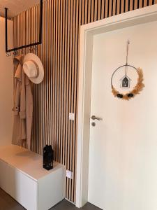 een gang met een witte kast en een hoed en een deur bij Ella House in Lingen +16 foto's