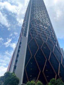 a tall building with a blue sky in the background at Scarletz suites klcc Twin Tower by ESD in Kuala Lumpur