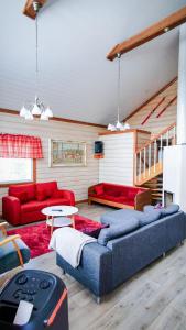 un soggiorno con divano blu e divani rossi di Luksushuvila louhosjärven rannalla a Isokyrö