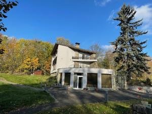 a large white house with a tree in front of it at Penzion BránaBeskyd in Frýdlant nad Ostravicí