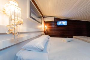 Un dormitorio con una cama con un televisor en la pared. en Pôr do Sol Ilha do Mel Pousada e Receptivo, en Ilha do Mel