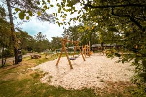 a playground with a swing set in a park at De Berk in Zuidwolde +11 photos
