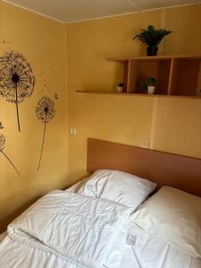 a bed in a bedroom with dandelions on the wall at De Berk in Zuidwolde