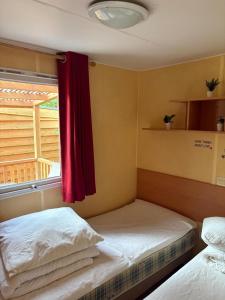 a bedroom with two beds and a red curtain at De Berk in Zuidwolde