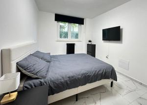 a white bedroom with a bed and a television at Casa Rossini - Moderno appartamento a due passi dal mare in Pescara