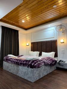 パハルガムにあるHotel crystalの木製の天井と大きなベッドのある寝室