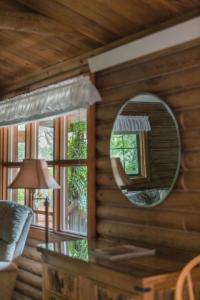a mirror on the wall of a log cabin at HONEYSUCKLE - Rustic cabin for 2 in Oak Creek Canyon in Indian Gardens