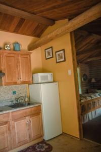 a kitchen with a refrigerator and a microwave at HONEYSUCKLE - Rustic cabin for 2 in Oak Creek Canyon in Indian Gardens