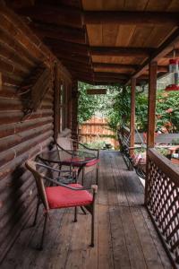 a porch with chairs and tables on a cabin at HONEYSUCKLE - Rustic cabin for 2 in Oak Creek Canyon in Indian Gardens +9 photos