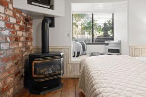 ein Schlafzimmer mit einem gemauerten Kamin neben einem Bett in der Unterkunft Adobe Village Studio Suite- Tumbleweed in Oak Creek