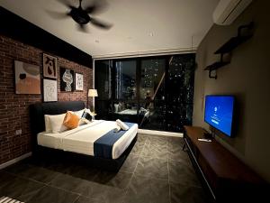 a bedroom with a bed and a window with a television at Scarletz suites klcc Twin Tower by ESD in Kuala Lumpur
