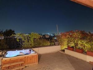 een persoon in een hot tub op een balkon 's nachts bij The olive tree in Harduf