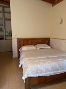 een slaapkamer met een groot bed met witte lakens bij The olive tree in Harduf