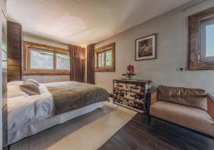 une chambre avec un lit et une chaise dans l'établissement Chalet Artic - 5 bedrooms - Bed&Breakfast - Courchevel 1550, à Courchevel