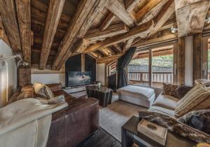 Elle comprend un salon doté d'un mobilier en cuir et de plafonds en bois. dans l'établissement Chalet Artic - 5 bedrooms - Bed&Breakfast - Courchevel 1550, à Courchevel