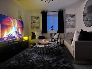 sala de estar con sofá y TV de pantalla grande en Van Loon Residence, en Oldbury