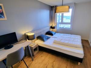 a bedroom with a bed and a desk with a television at Appartement moderne 3 pièces aux Arcs 1800 - FR-1-346-537 in Arc 1800