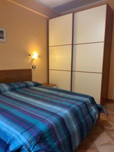 a bedroom with a large bed with a blue blanket at La Piccola Stella in Castel del Giudice