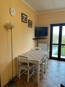 a dining room with a table and chairs and a clock at La Piccola Stella in Castel del Giudice