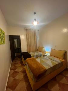 een slaapkamer met twee bedden en een bank erin bij un vrai repos in Essaouira