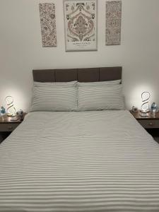 ein Schlafzimmer mit einem großen Bett mit zwei Nachttischen in der Unterkunft The Bungalow by SJP - Double Room in Northamtonshire