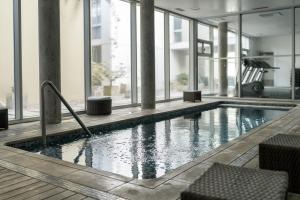 einen Pool in einem Gebäude mit Fenstern in der Unterkunft Altos Del Plata 105 y 505 Colonia Uruguay in Colonia del Sacramento