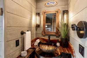 a bathroom with a wooden sink and a mirror at "Air Fort One" Aviation-Themed Luxury Treehouse Near Dollywood & Pigeon Forge in Sevierville