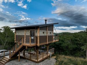 a house on a tree stump with a deck at "Air Fort One" Aviation-Themed Luxury Treehouse Near Dollywood & Pigeon Forge in Sevierville
