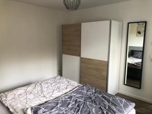 ein Schlafzimmer mit einem Bett und einem Spiegel in der Unterkunft Ferienwohnung Wanner in Amtzell