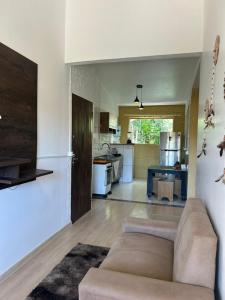 ein Wohnzimmer mit Couch und Küche in der Unterkunft Do sol in Porto Seguro