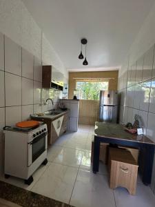 eine Küche mit Herd und Spüle in der Unterkunft Do sol in Porto Seguro