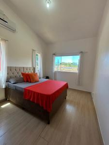 ein Schlafzimmer mit einem großen Bett mit einer roten Decke in der Unterkunft Do sol in Porto Seguro