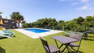 Un patio con mesa y sillas y una piscina. en Casa Mágica piscina privada, en La Esquinita