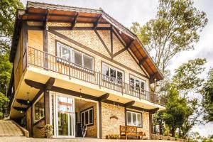 a house with a balcony on top of it at VELINN Pousada Pedras e Sonhos in Monte Verde +21 photos