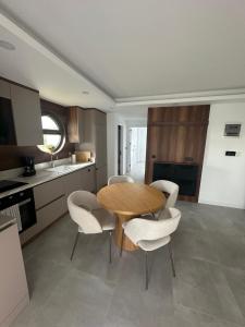 a kitchen with a wooden table and white chairs at Charmante, moderne Wohnung 10 Minuten Fußweg zum Strand! in Side