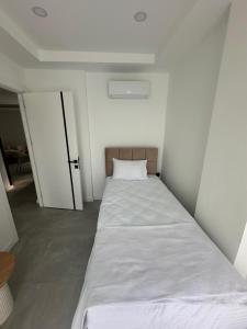 a bed in a small room with a door at Charmante, moderne Wohnung 10 Minuten Fußweg zum Strand! in Side +2 photos
