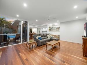 a living room with a couch and a table at 3 Moffat Beach Holiday House in Caloundra