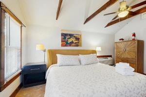 a bedroom with a white bed and a window at Main Street Wood Cottage in Brevard