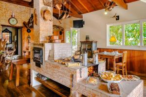 a kitchen with a large stone oven with food on a table at VELINN Pousada Pedras e Sonhos in Monte Verde