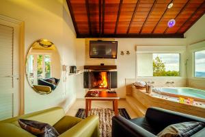 a living room with a tub and a fireplace at VELINN Pousada Pedras e Sonhos in Monte Verde