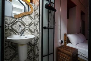 a bathroom with a sink and a mirror and a bed at Otel Mahlas in Şahinbey +45 photos