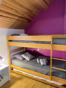 een stapelbed in een kamer met een paarse muur bij Cocon cosy au cœur des Pyrénées in Campan