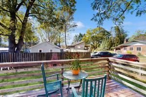 einen Tisch und Stühle auf einer Terrasse mit einem Zaun in der Unterkunft Main Street Brick Cottage in Brevard