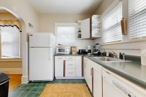 eine Küche mit weißen Geräten und einem weißen Kühlschrank in der Unterkunft Main Street Brick Cottage in Brevard
