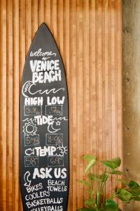 een surfplank met tekst erop op een muur bij Hotel Erwin Venice Beach in Los Angeles