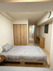 ein Schlafzimmer mit einem Bett und einer Uhr an der Wand in der Unterkunft # 3 Katsu House日本桥地铁站6分 in Wada