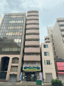 ein hohes Gebäude mit einem Schild davor in der Unterkunft # 3 Katsu House日本桥地铁站6分 in Wada