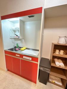 eine kleine Küche mit einem roten Schrank und einem Waschbecken in der Unterkunft # 3 Katsu House日本桥地铁站6分 in Wada